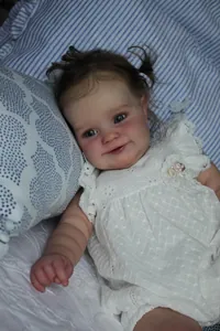 Detailed close-up of reborn baby doll Maddie featuring realistic facial features and lace dress