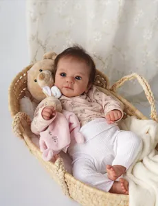 Detailansicht der 19-Zoll lebensechten Reborn-Puppe im Weidenkorb mit Plüschbär