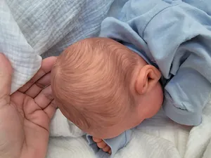 Close-up of 19 inch Reborn Doll Miley with realistic hand-painted hair and blue cotton outfit