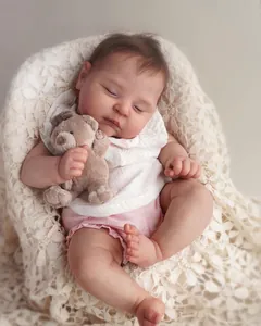 Gros plan d'une poupée reborn réaliste endormie avec peau 3D et ours en peluche