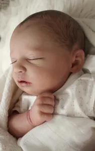 Close-up of reborn baby doll showing realistic skin texture and sleeping face