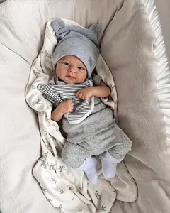 Detailansicht graues Baby-Kleidungsset aus Rippstrick mit Mütze und Lätzchen auf Decke