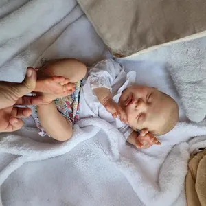 Lifelike 22-inch reborn baby doll with 3D skin texture and floral outfit on plush rug