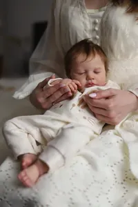 Macro detail of LouLou reborn doll showing realistic skin texture and closed eyes