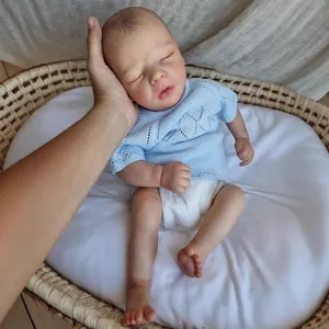 Realistic 16-inch sleeping reborn baby doll in blue knit sweater and woven basket