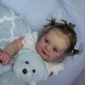 Realistic 60cm reborn baby girl doll Maddie in white lace outfit with a blue plush bear