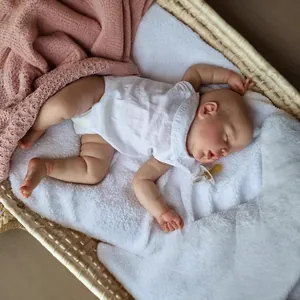 22-inch realistic sleeping reborn baby doll with 3D skin texture in a woven cradle