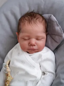 Close-up of lifelike reborn baby doll face featuring realistic skin and soft sheep print outfit