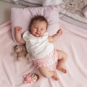 Poupée Reborn Peaches réaliste avec texture de peau 3D, dormant dans un lit rose et blanc