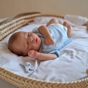 Realistic 16-inch sleeping reborn baby doll in knit outfit resting in a woven basket