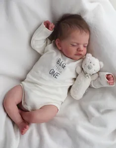 Detailed realistic reborn baby doll Sam sleeping with a white teddy bear on a plush rug