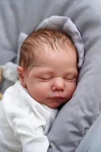 Macro close-up of 19-inch reborn baby doll showing realistic skin and sleeping expression