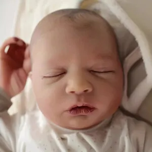 Lifelike 19 inch reborn baby doll in a floral onesie sleeping peacefully on soft fabric