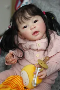 Detailed view of 60cm realistic reborn baby doll with pigtails and plush duck toy
