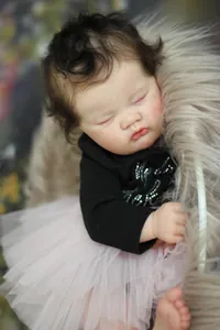 Detailed close-up of 19-inch sleeping reborn baby doll with realistic skin and brown hair