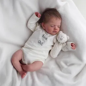 Realistic 18-inch sleeping reborn baby doll Sam in white romper with plush bear