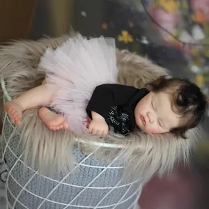 Realistic 19-inch sleeping reborn baby doll in pink tutu sitting in a wire basket
