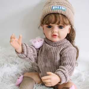 Dettaglio di una bambola reborn realistica da 55cm con cappello e maglione in maglia