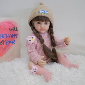 Lifelike 55cm reborn baby doll in pink knit sweater and khaki beanie on white rug