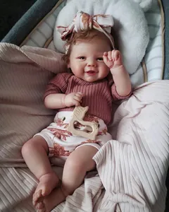 Détail d'une poupée reborn 19 pouces en tenue côtelée rose et short fleuri avec jouet en bois