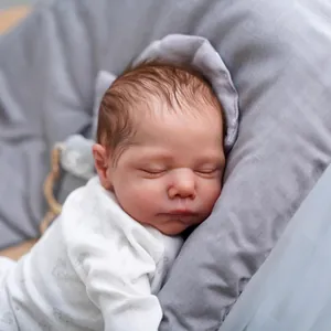 Lifelike 19-inch reborn baby doll sleeping in white printed outfit with realistic skin