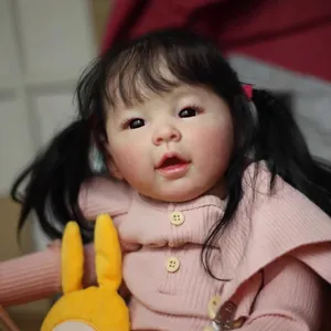 Realistic 60cm baby girl doll with pigtails in pink knit top holding a plush bunny