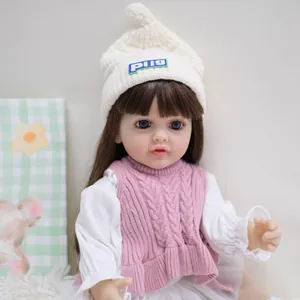55cm realistische Reborn babypop met bruin haar, blauwe ogen en een roze gebreid vest