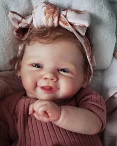 Gros plan d'une poupée reborn de 19 pouces souriante aux cheveux bouclés et tenue rose
