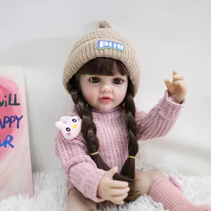 55cm realistic reborn baby doll with brown pigtails and pink knit sweater on soft rug