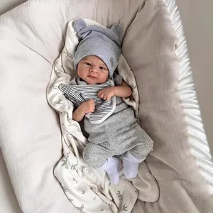 Realistische 46cm Elijah Puppe mit 5-teiligem grauen Strickset und Lätzchen im Babybett