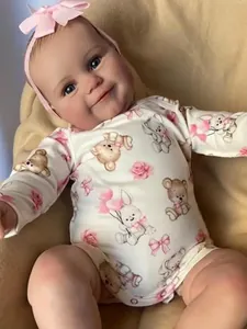Close-up of Maddie reborn baby doll in white floral romper with pink satin bow headband