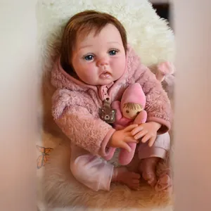 Poupée bébé reborn de 55cm avec sweat à capuche rose pelucheux sur tapis en fourrure