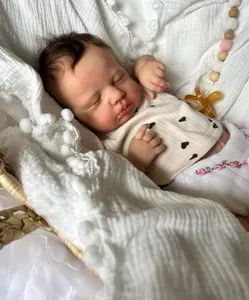 Gros plan détaillé d'une poupée reborn réaliste de 19 pouces dans un panier en osier blanc