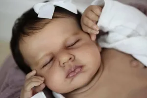 Close-up of lifelike 19-inch reborn baby doll face with detailed skin texture and bow