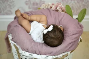 Close-up of white grosgrain ribbon bow headband worn by newborn baby for photoshoot