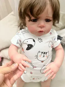 Close-up of 60cm reborn doll with lifelike skin and hand-held detail in cat print romper