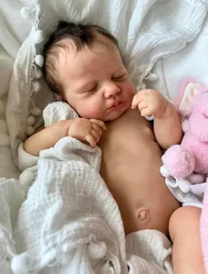 Gros plan d'une poupée Reborn LouLou réaliste dormant dans des langes en coton blanc