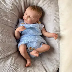 Realistic 48cm reborn baby doll sleeping in light blue knit overalls on a grey blanket