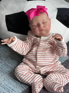 Detailed close-up of 20 inch reborn baby doll with 3D skin texture in striped outfit