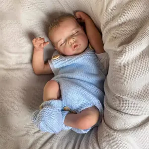 Lifelike 48cm sleeping reborn baby doll in blue knit outfit on soft white blanket