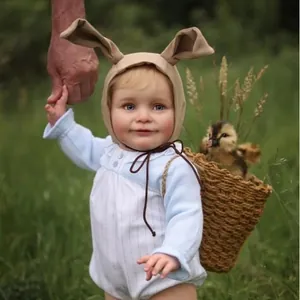 Detail of 55cm baby doll clothes set featuring blue rabbit ear hat and striped romper
