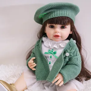 Détail poupée bébé réaliste 55cm avec bonnet tricoté vert, gilet et cheveux bruns