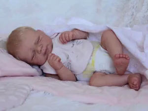 Detailed macro shot of 50cm reborn baby doll showing realistic skin texture and sleeping face