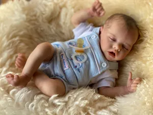 Makro-Detail einer lebensechten Reborn-Babypuppe im Day Dreamer Latzhosen-Outfit
