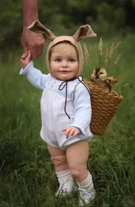Detail of reborn baby doll clothing set with blue striped romper and rabbit ear hat
