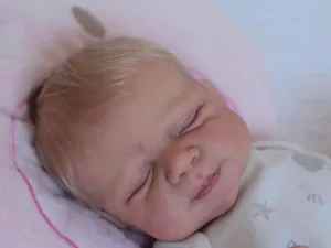 Macro detail of 50cm sleeping reborn doll with blonde hair and star print clothing