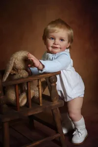 Detailed view of Zoe reborn baby doll with blonde hair, blue eyes and knitted outfit