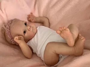 Détails réalistes de la peau d'un poupon reborn sur un fond en peluche rose
