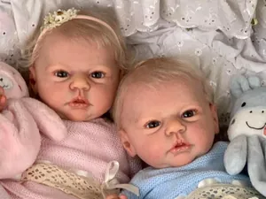 Close-up of lifelike 19-inch newborn dolls with realistic skin texture and knit outfits