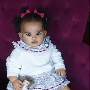 Détails d'une poupée reborn de 55cm en robe fleurie sur un canapé en velours violet